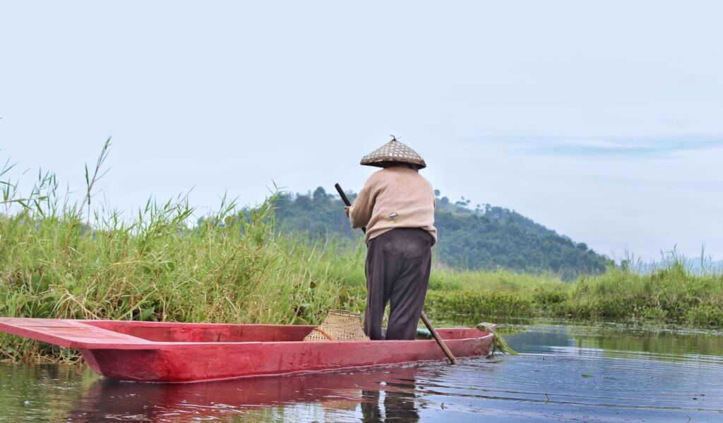 Fishermen on his wooden country boat on waters of Loktak Lake