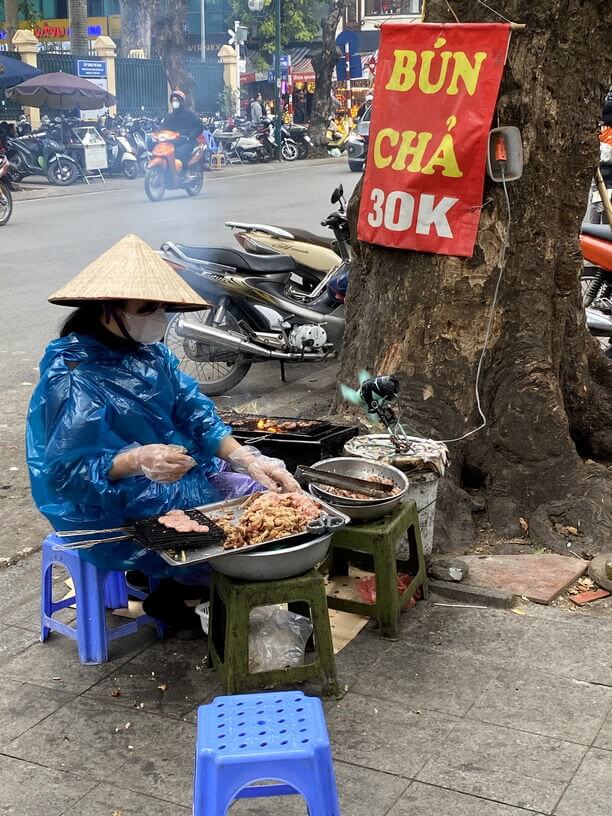 Lady on streets of Hanoi preparing Hanoi speciality cuisine Bun Cha
