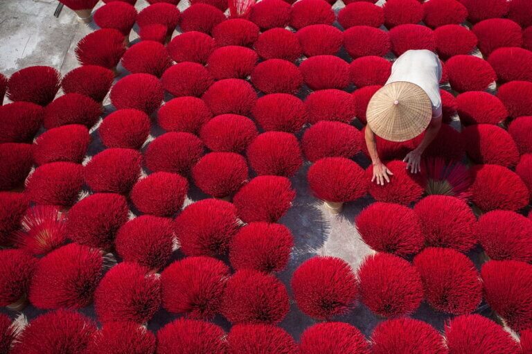 A girl sitting across the incense stick in the incense village of Vietnam - Quang Phu Cau, Hanoi