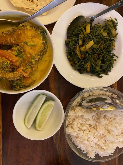 Spread of authentic Assamese food - Mustard fish curry, Dhekia, rice and Assamese Lemon
